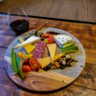 foto van een marmere borrelplank belegt met kaas en worst en een glas rode wijn