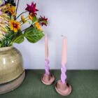 Foto van twee paars-roze twisted kaarsen in een roze kaarsenhouder