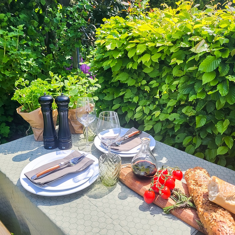 afbeelding-van-een-gedekte-tafel-met-witte-dinerborden-en-versdecoratie