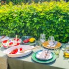 afbeelding-van-een-gedekte-tafel-diverse-schalen en het servies getoond in zowel wit als groen met umbre