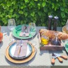 afbeelding-van-een-gedekte-tafel-met-groene-en-umbre-dinerborden-en-houten-kistje-in-het-midden
